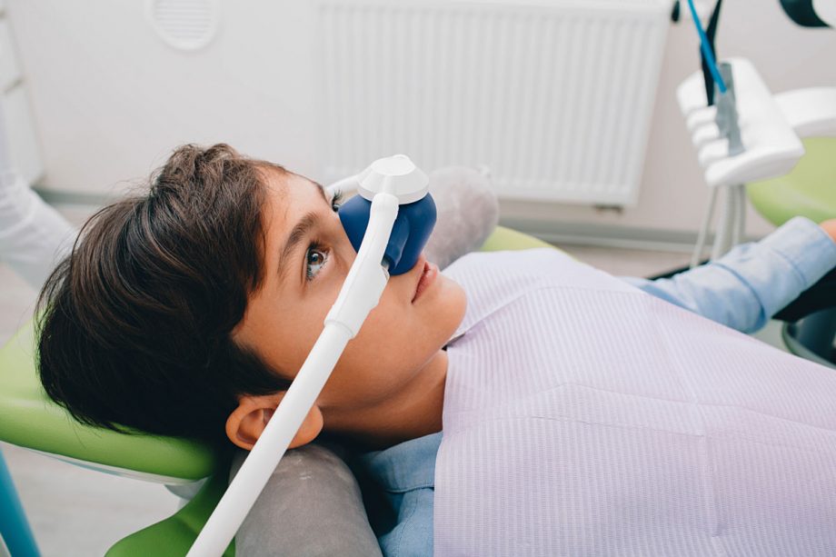 young boy reclining in dental chair receiving sedation