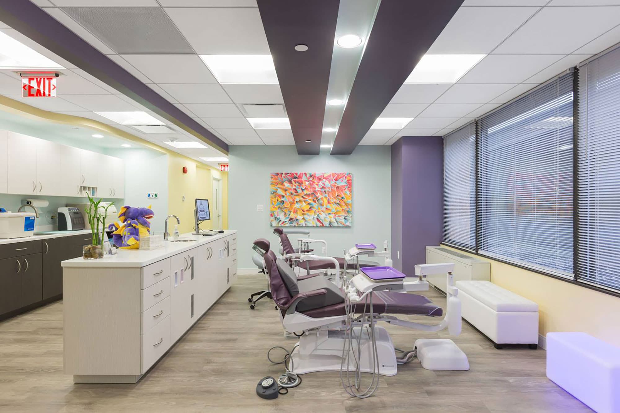 dental examination area with purple and yellow accents with white cabinets