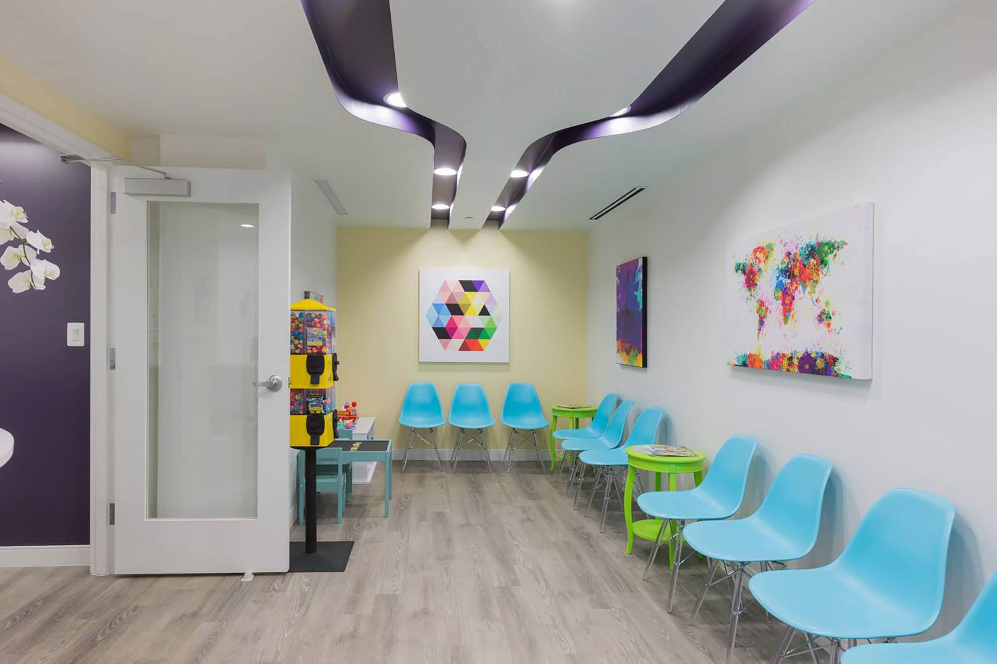 dental reception area with turquoise seats, kids play table and toy vending machines