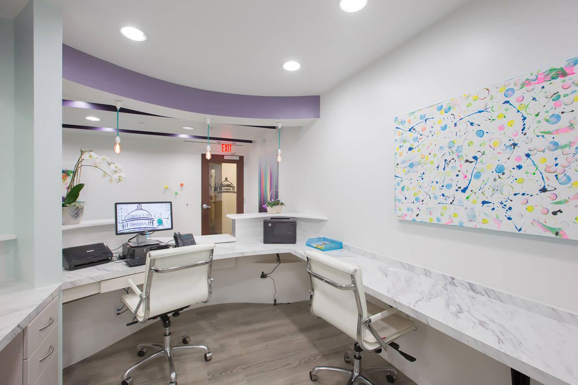 office space for receptionists at dental office with white chairs and counters